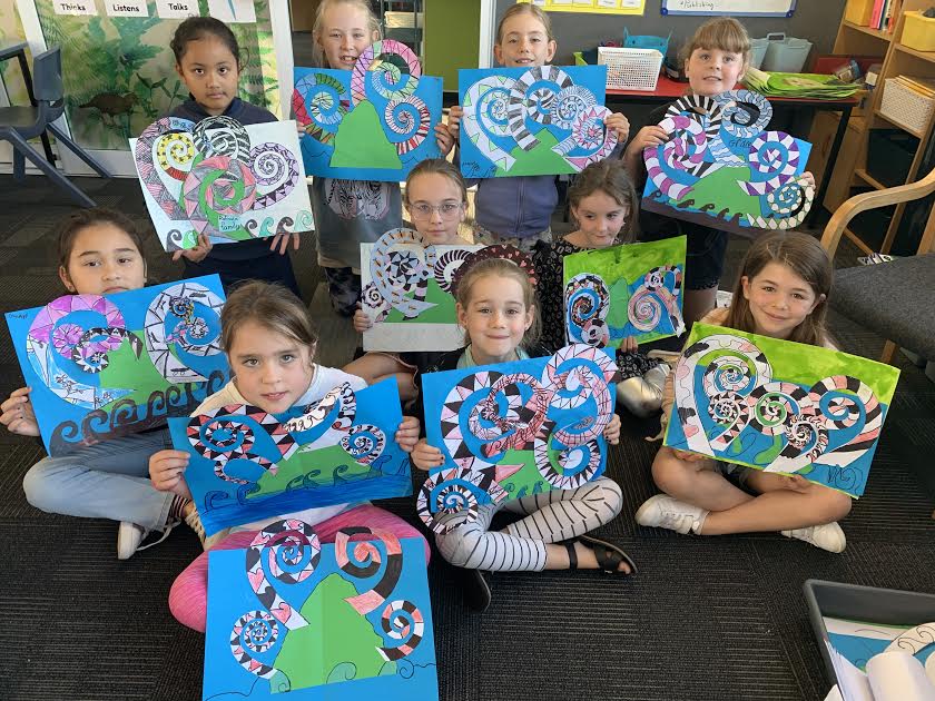 Papanui Primary students holding up their artwork